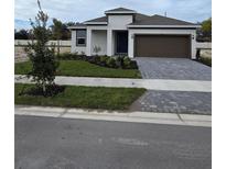 New construction home with two-car garage and landscaped yard at 9613 Vibrant Lane, Venice, FL 34292