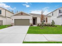 Newly constructed home with a two-car garage and well-manicured lawn at 37508 Williamette Way, Zephyrhills, FL 33540