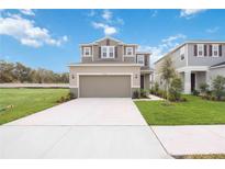 Two-story house with attached garage and landscaped yard at 37736 Yukon Dr, Zephyrhills, FL 33540