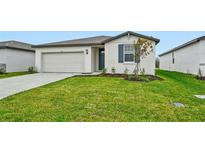 Single-story home with a white exterior, two-car garage, and landscaped lawn at 7760 Gilchrist Springs Dr, Parrish, FL 34219