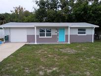 Newly renovated home with gray exterior, turquoise door, and attached garage at 4652 Alma St, New Port Richey, FL 34652