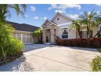 Inviting home with brick facade, landscaping, and two-car garage at 11909 Mandevilla Ct, Tampa, FL 33626