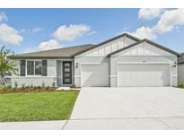 New two-story home with gray exterior, two-car garage, and landscaped lawn at 14006 Ginnie Springs Way, Parrish, FL 34219