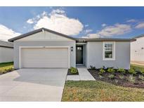 Newly constructed one-story home with gray exterior, two-car garage, and landscaped front yard at 169 Lazy Shore Dr, Nokomis, FL 34275