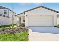 One-story home with white exterior, two-car garage, and landscaping at 14053 Crutchfield Ct, Parrish, FL 34219