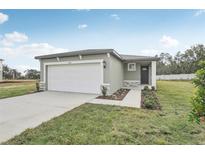 Newly constructed home with a white garage door and landscaped front yard at 3622 Moscato Dr, Brooksville, FL 34602