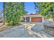 House exterior showcasing carport and orange garage door at 990 Sunrise Dr, Tarpon Springs, FL 34689