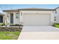Modern one-story home with attached garage and landscaping at 14037 Crutchfield Ct, Parrish, FL 34219