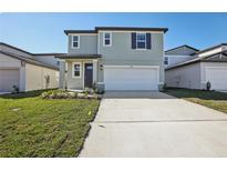 Two-story house with gray siding, two-car garage, and a well-maintained lawn at 3919 Radiant Mountain Dr, Plant City, FL 33565