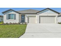 Two-story house with light-colored siding, gray shutters, and a two-car garage at 13859 Richland Gulf Cir, Parrish, FL 34219