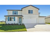 Two-story house with a two-car garage and teal accents at 13868 Richland Gulf Cir, Parrish, FL 34219