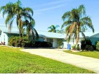 Charming single-story home with a metal roof, lush landscaping, and a spacious driveway at 1908 40Th W St, Bradenton, FL 34205