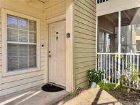 Exterior view of condo building, showing a light beige building with a white door and small patio area at 803 Lake Haven Sq # 106, Brandon, FL 33511