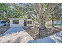 Charming bungalow home with a large tree and a paved driveway at 634 Newton S Ave, St Petersburg, FL 33701