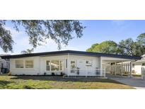 Updated mid-century modern home with white exterior, black roofline, and landscaped lawn at 4260 Des Plaines Dr, Sarasota, FL 34233