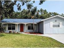Charming one-story home with a red door and landscaped yard at 152 Clemson Rd, Venice, FL 34293