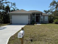 Charming single-story home with a well-maintained lawn and a two-car garage at 135 Sunset Rd, Rotonda West, FL 33947