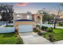 Two-story house with attached garage, landscaping, and a white fence at 8115 61St N St, Pinellas Park, FL 33781