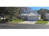 Charming single-story home features a well-manicured lawn and an attached two-car garage at 1287 Lakeside Woods Dr, Venice, FL 34285
