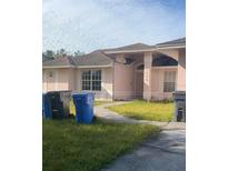 One-story house with light pink walls and a dark gray roof at 1438 Mclin Dr, Plant City, FL 33565