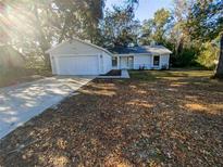 Newly constructed home with a white exterior, attached garage, and a spacious yard at 1505 Larkin Rd, Spring Hill, FL 34608