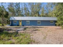 Ranch style home with metal roof and yellow door at 5117 Behms Ct, Port Richey, FL 34668