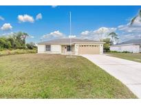 Single-story house with attached garage and a spacious lawn at 4944 Alseir Rd, North Port, FL 34288
