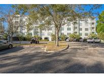 Exterior of a light-colored multi-story building with parking and landscaping at 210 3Rd W St # 8205, Bradenton, FL 34205