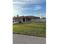 Single-story home with a well-manicured lawn and attached garage at 1000 Osceola Blvd, Englewood, FL 34223