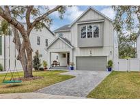 Two-story house with gray siding, a gray door and paved driveway at 6107 S 4Th St, Tampa, FL 33611