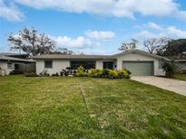 Charming single story home with a well manicured lawn and green garage door at 2801 65Th N Way, St Petersburg, FL 33710
