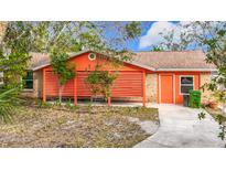 Bright orange house with covered patio and landscaped yard at 70 Horton Cir, Sarasota, FL 34232