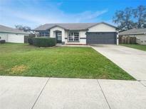 Charming one-story home with a well-manicured lawn and attached garage at 7224 Highland Loop, Zephyrhills, FL 33541