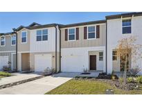 Two-story townhome with attached garage and landscaped yard at 6196 Pina Colada St, Zephyrhills, FL 33542