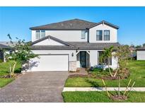 Two-story house with a white exterior, gray roof, and a two-car garage at 2546 Buckthorn Loop, North Port, FL 34289