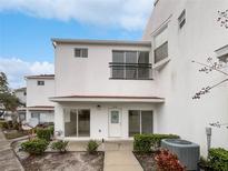 Two-story townhome with white exterior, private patio, and landscaping at 9416 Citrus Glen Pl, Tampa, FL 33618