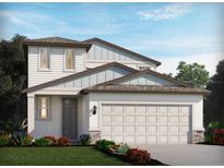 Two-story home with gray and white siding, a two-car garage, and landscaping at 1868 Brekey Way, Zephyrhills, FL 33541