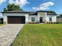 One-story home with dark brown garage door and landscaped lawn at 2827 Soprano Ln, North Port, FL 34286