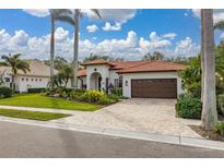 Single-story home with brown garage door, landscaped yard, and tile driveway at 6720 The Masters Ave, Lakewood Ranch, FL 34202