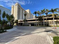 Luxury condo building with palm trees and ample parking at 750 N Tamiami Trl # 814, Sarasota, FL 34236