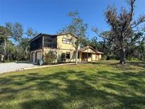 Two-story house with a screened porch, attached garage, and spacious yard at 7027 Hawkins Rd, Sarasota, FL 34241