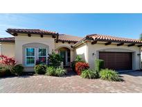 Single-story home with tile roof, landscaping, and two-car garage at 4777 Royal Dornoch Cir, Bradenton, FL 34211