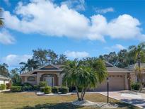 Single-story home with landscaped yard and two-car garage at 2321 E Del Webb Blvd, Sun City Center, FL 33573