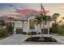 Two-story house with attached garage and palm trees in the front yard at 7092 Baypine Ln, Englewood, FL 34224