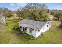 White house with gray roof, large yard, and trees at 2205 Mcgee Rd, Plant City, FL 33565