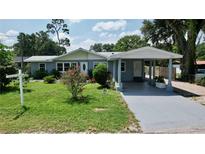 Newly painted light blue house with a carport and well-maintained lawn at 5213 Keene Dr, Plant City, FL 33566