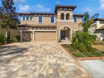 Two-story house with a three-car garage and a paver driveway at 23849 Sicilia Pass, Land O Lakes, FL 34639