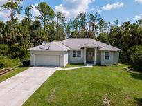 Single-story house with a two-car garage and a spacious yard at 4126 Cobbler Ln, North Port, FL 34286