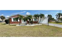 Brick ranch home with palm trees and a well-maintained lawn at 705 Brannen Cir, Sun City Center, FL 33573