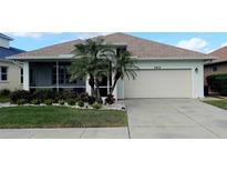 Single-story home with attached garage, palm trees, and well-manicured lawn at 1835 Scarlett Ave, North Port, FL 34289